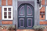 Rundbogenhaustür in schwarz mit lila Highlights