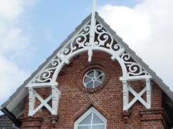 Holzverzierung bei Steinhaus in weiß