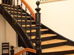 Holztreppe mit schwarzem Geländer