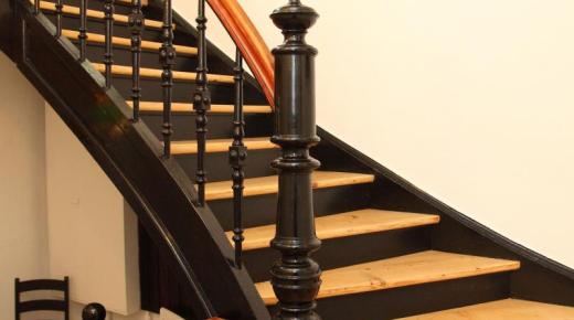 Holztreppe mit schwarzem Geländer 