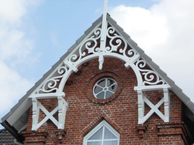 Holzverzierung bei Steinhaus in weiß 