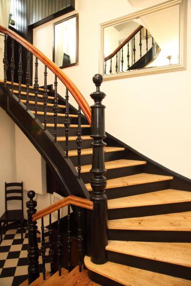 Holztreppe mit schwarzem Geländer 